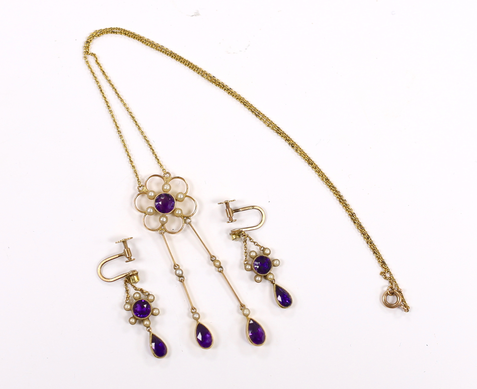 An Edwardian yellow metal, amethyst and seed pearl cluster set drop pendant necklace, 48cm and a pair if matching drop ear clips, gross weight 8.3 grams.
